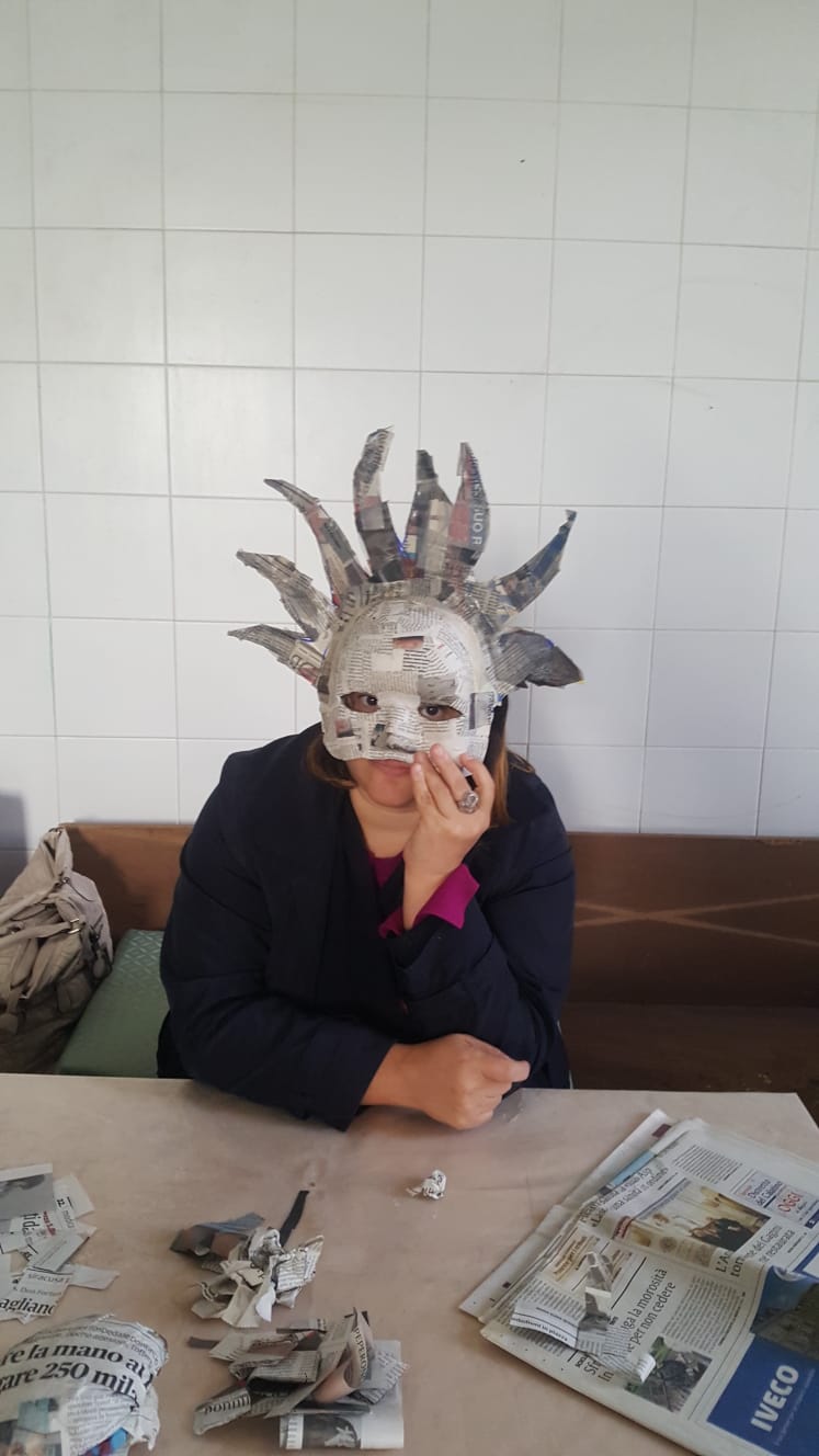 Partecipante con una maschera in cartapesta realizzata al laboratorio